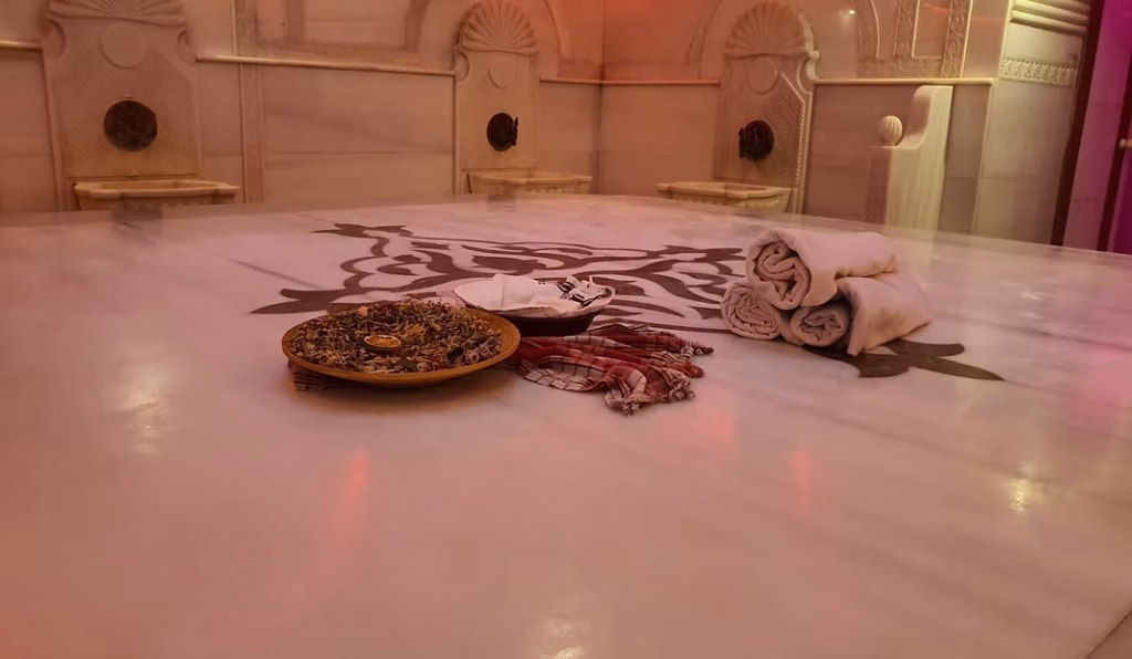 Acemoğlu Tarihi Hamam’da geleneksel göbek taşı üzerinde kese ve havlu ile hazırlanan Osmanlı tarzı hamam deneyimi.