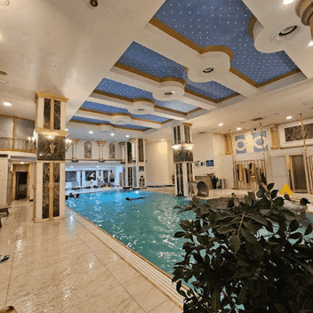 Acemoğlu Hamamı spa merkezi – süslemeli tavan ve geniş yüzme havuzuyla lüks dinlenme alanı.